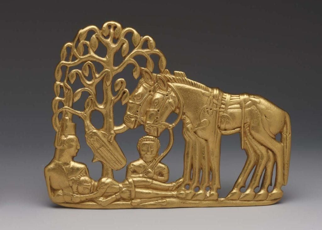 Gold belt plaque depicting three Scythians resting under a tree, two bridled horses standing next to them